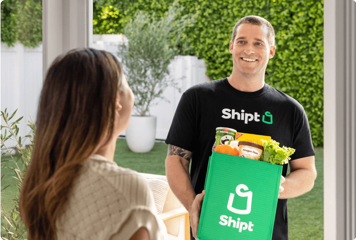 Shopper delivering a Shipt green bag to customer at door